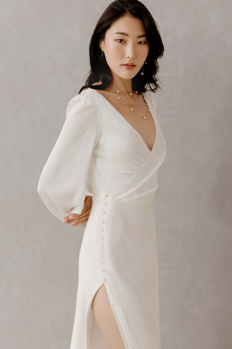 Elegante Braut in Satin-Hochzeitskleid mit langen Bischofsärmeln, offenem Rücken und seitlichem Schlitz im Rock, Hamburg