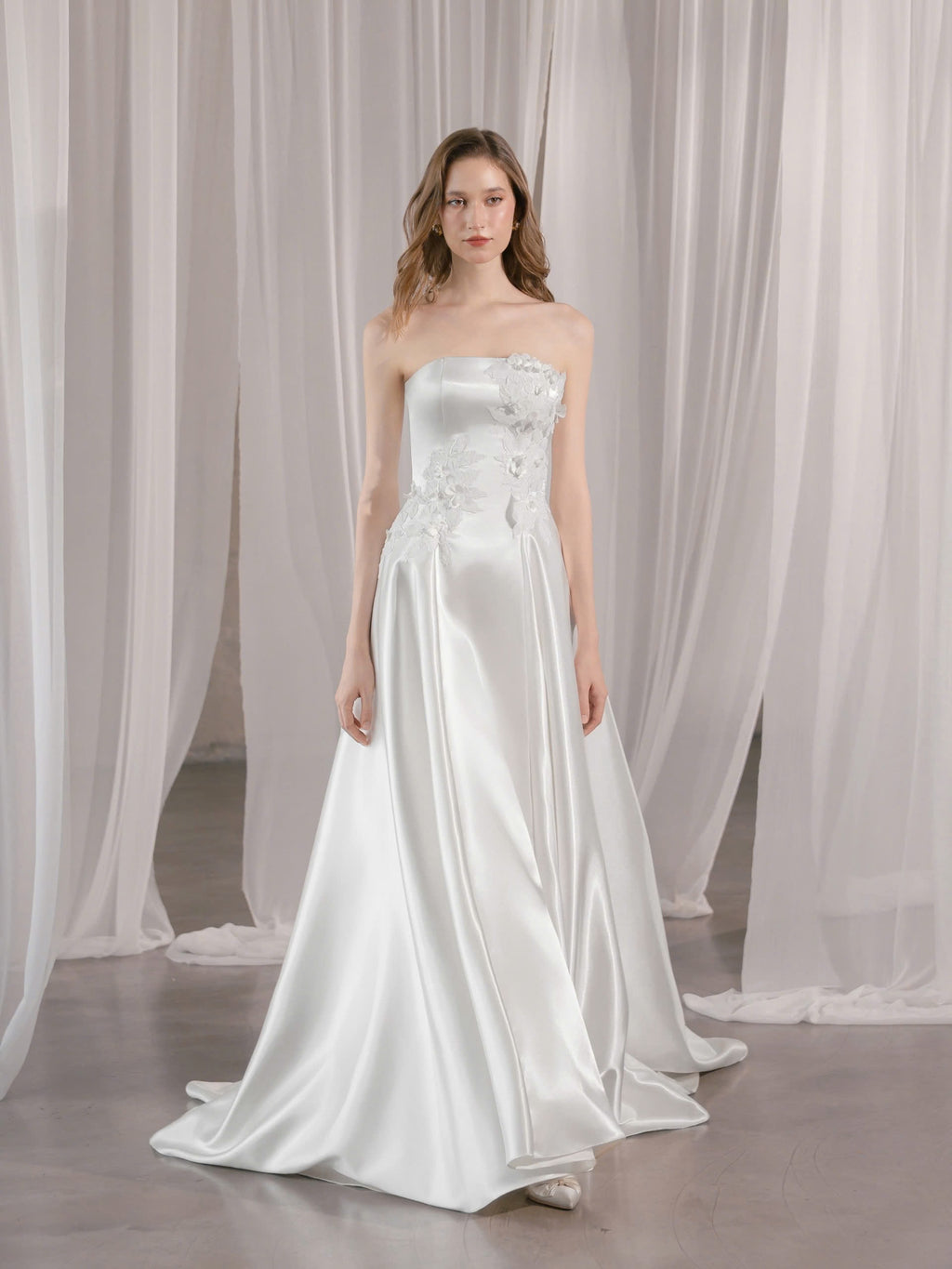 Trägerloses Brautkleid mit geradem Ausschnitt und asymmetrischen 3D-Blütenapplikationen Hamburg Brautmode