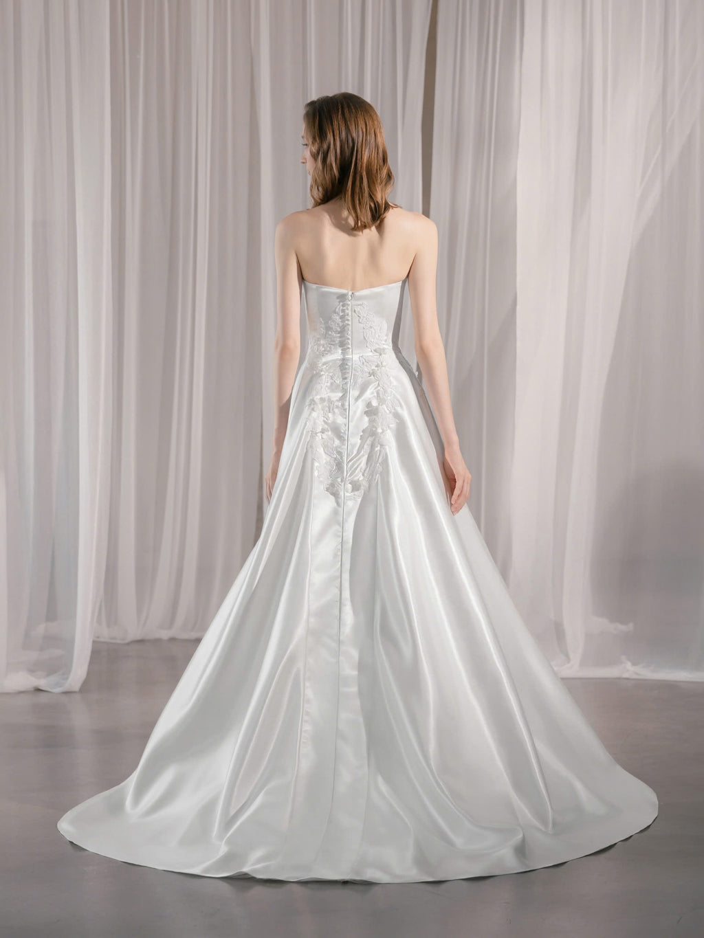Trägerloses Brautkleid mit geradem Ausschnitt und asymmetrischen 3D-Blütenapplikationen Hamburg Brautmode