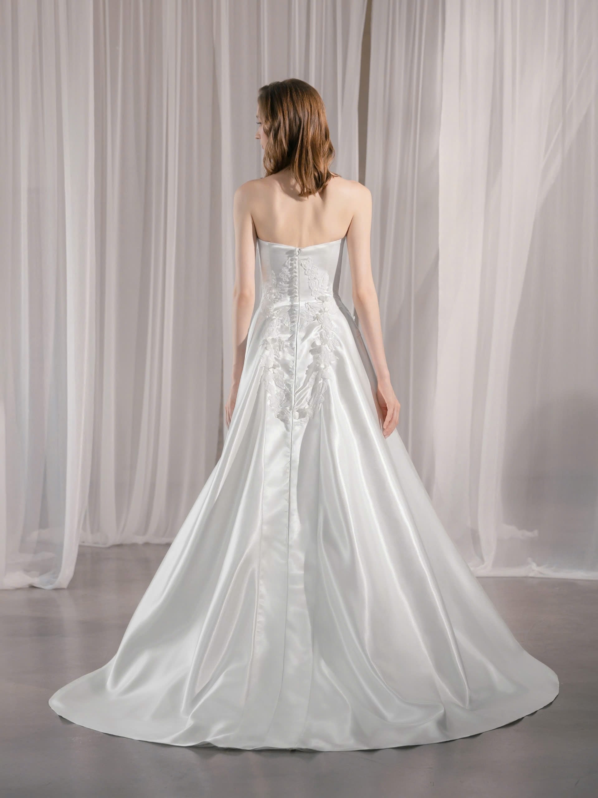 Trägerloses Brautkleid mit geradem Ausschnitt und asymmetrischen 3D-Blütenapplikationen Hamburg Brautmode