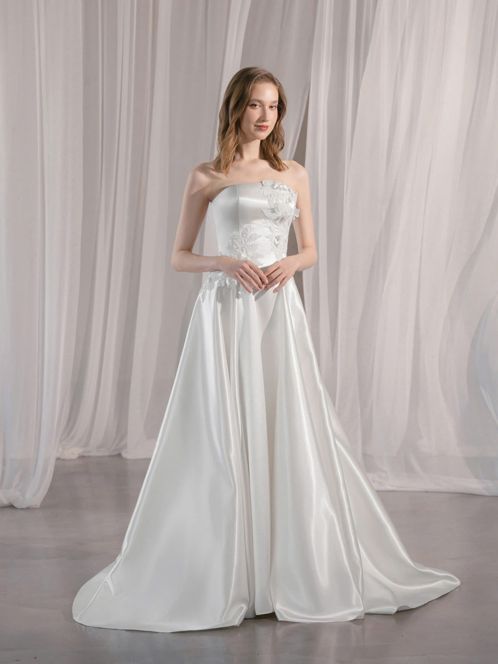 Trägerloses Brautkleid mit geradem Ausschnitt und asymmetrischen 3D-Blütenapplikationen Hamburg Brautmode