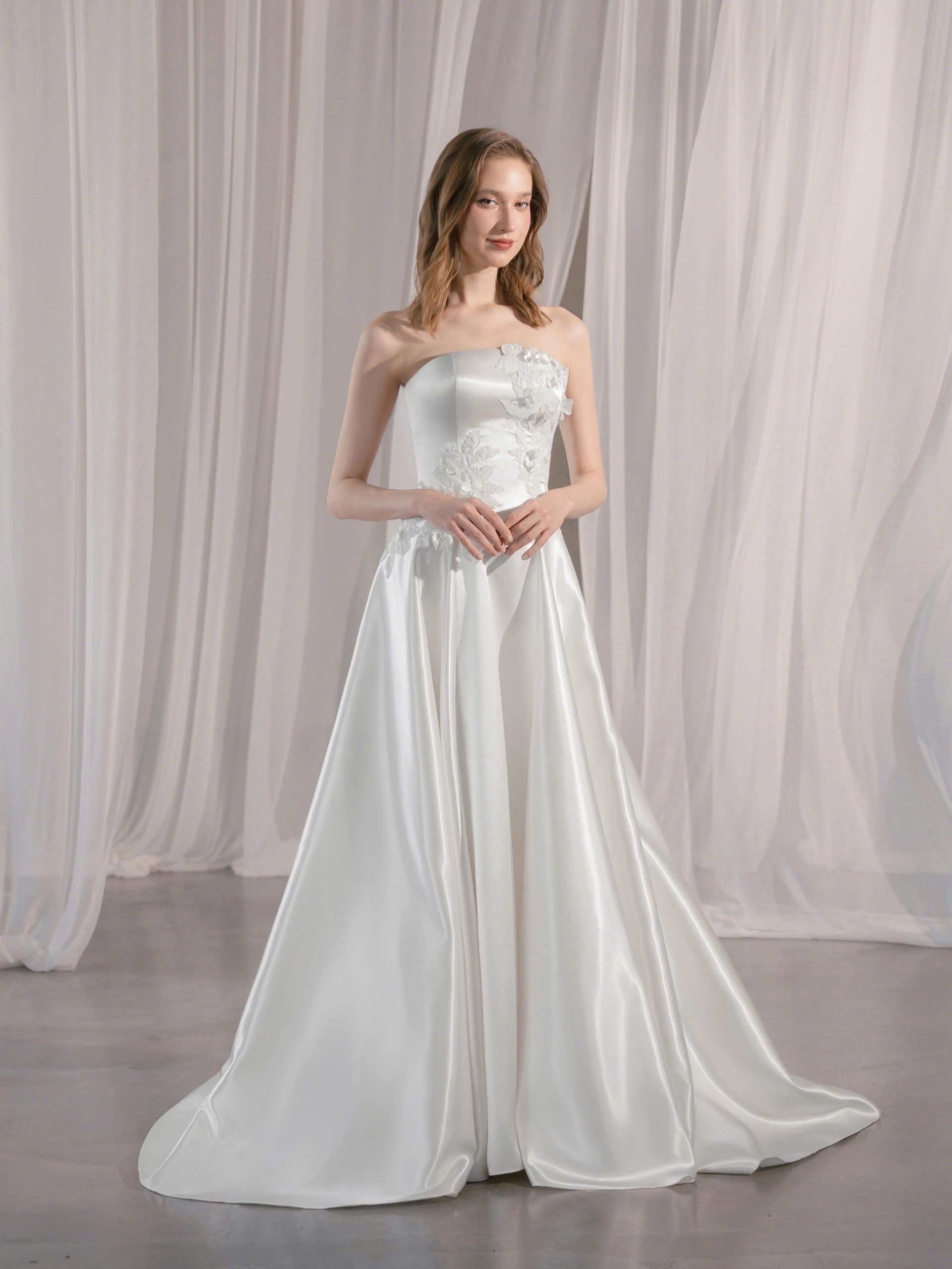 Trägerloses Brautkleid mit geradem Ausschnitt und asymmetrischen 3D-Blütenapplikationen Hamburg Brautmode