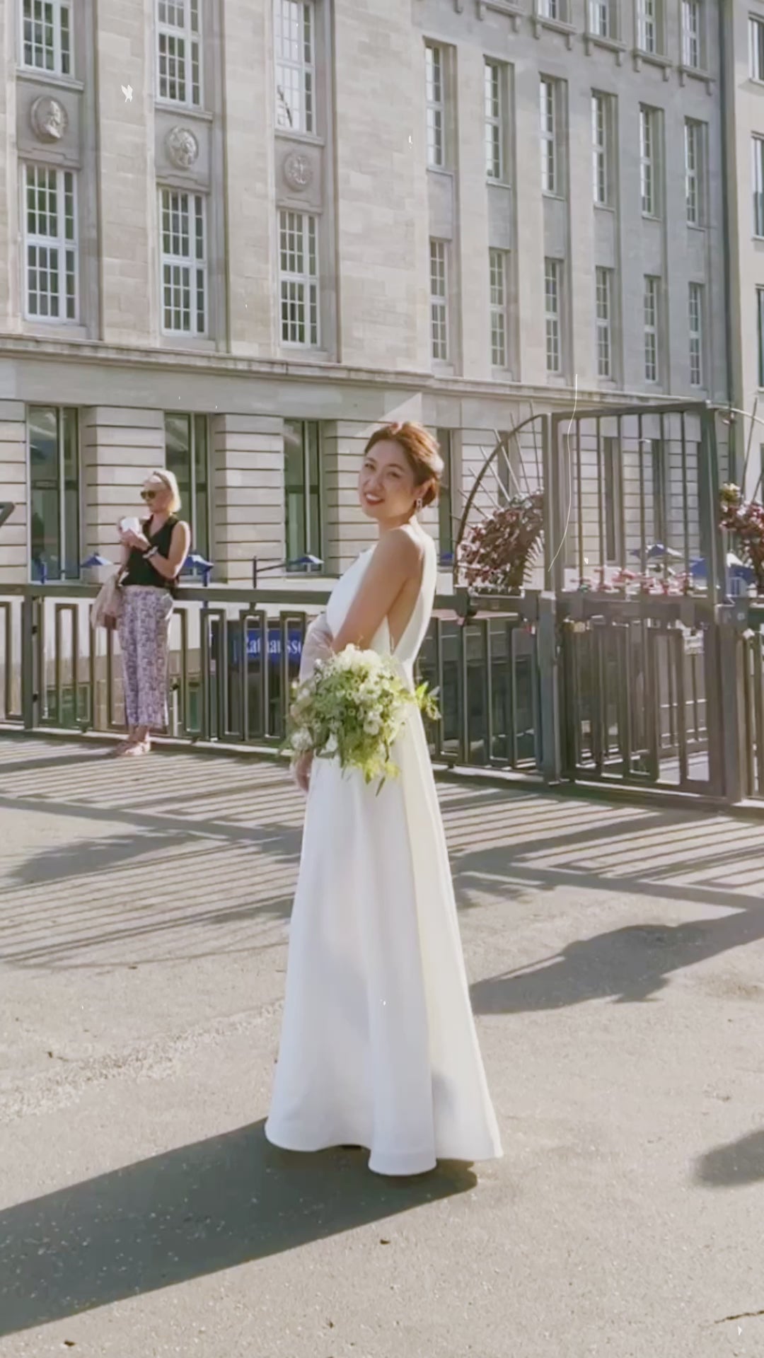Elegante Braut in ärmellosem Hochzeitskleid aus Satin mit transparenten Seiten, Hamburg.